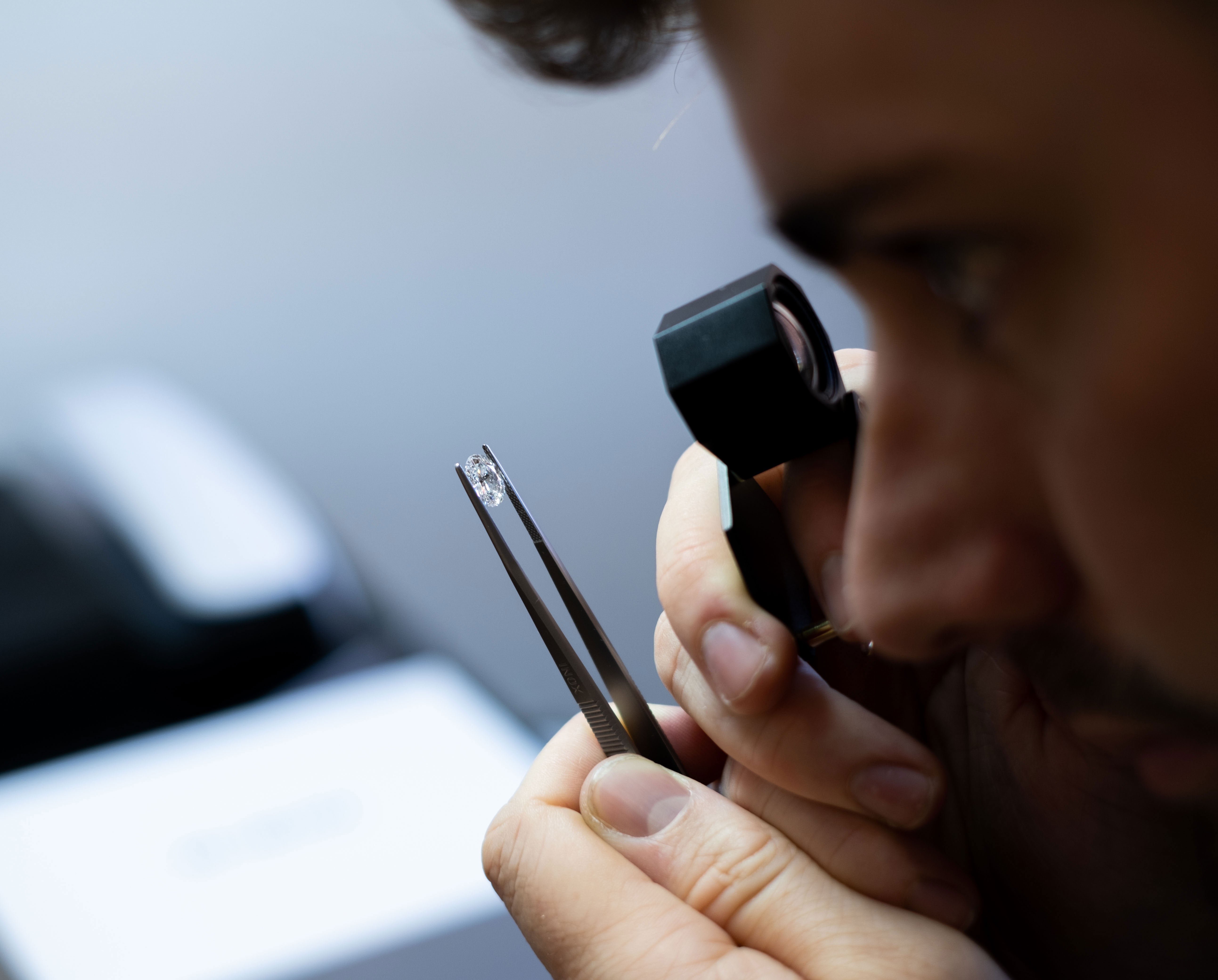 Harry looking at a loose lab grown diamond. Ready to be made into an engagement ring in london, uk