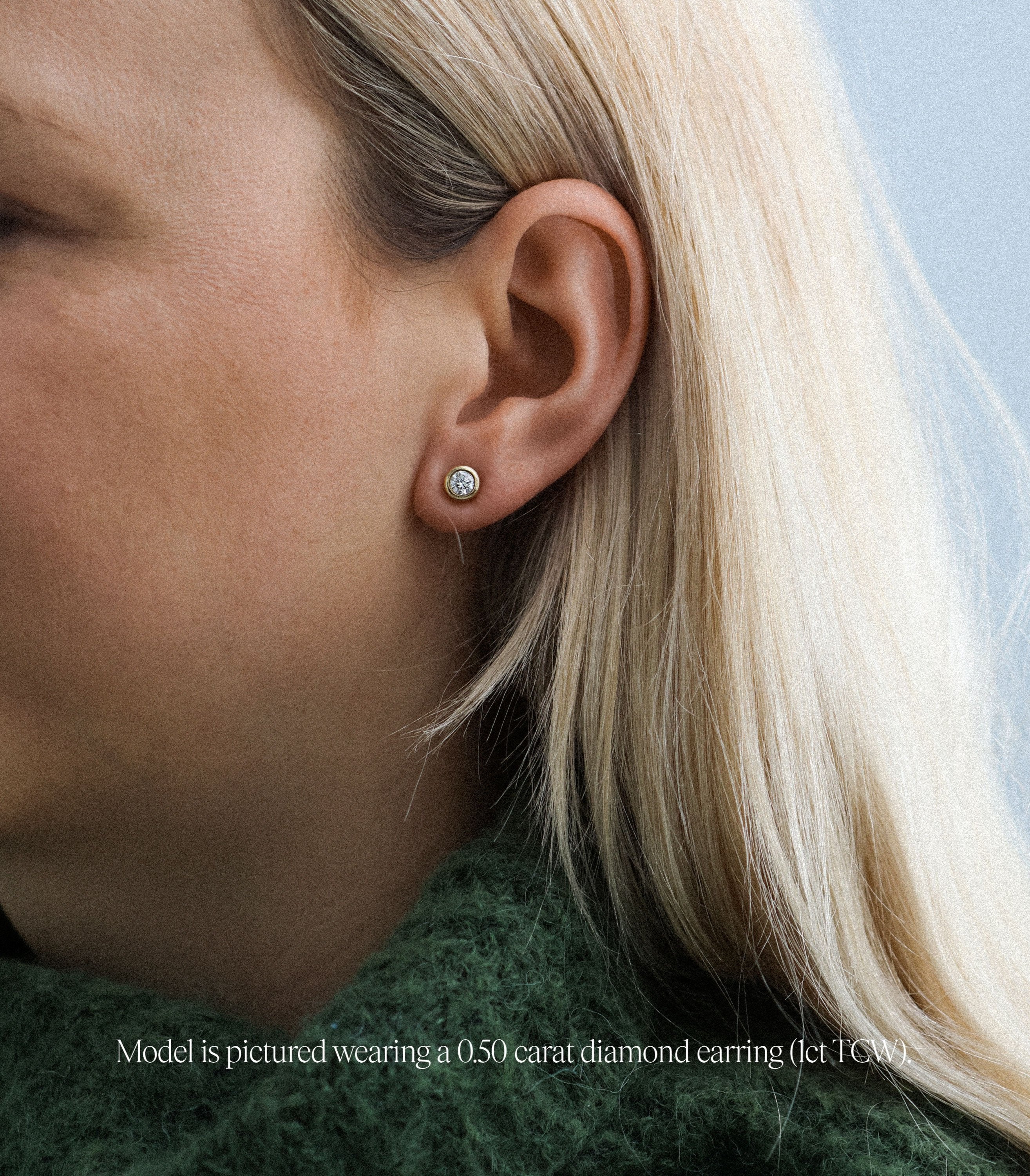 chunky round rubover stud earrings made with lab grown diamonds in recycled yellow gold. On Model.