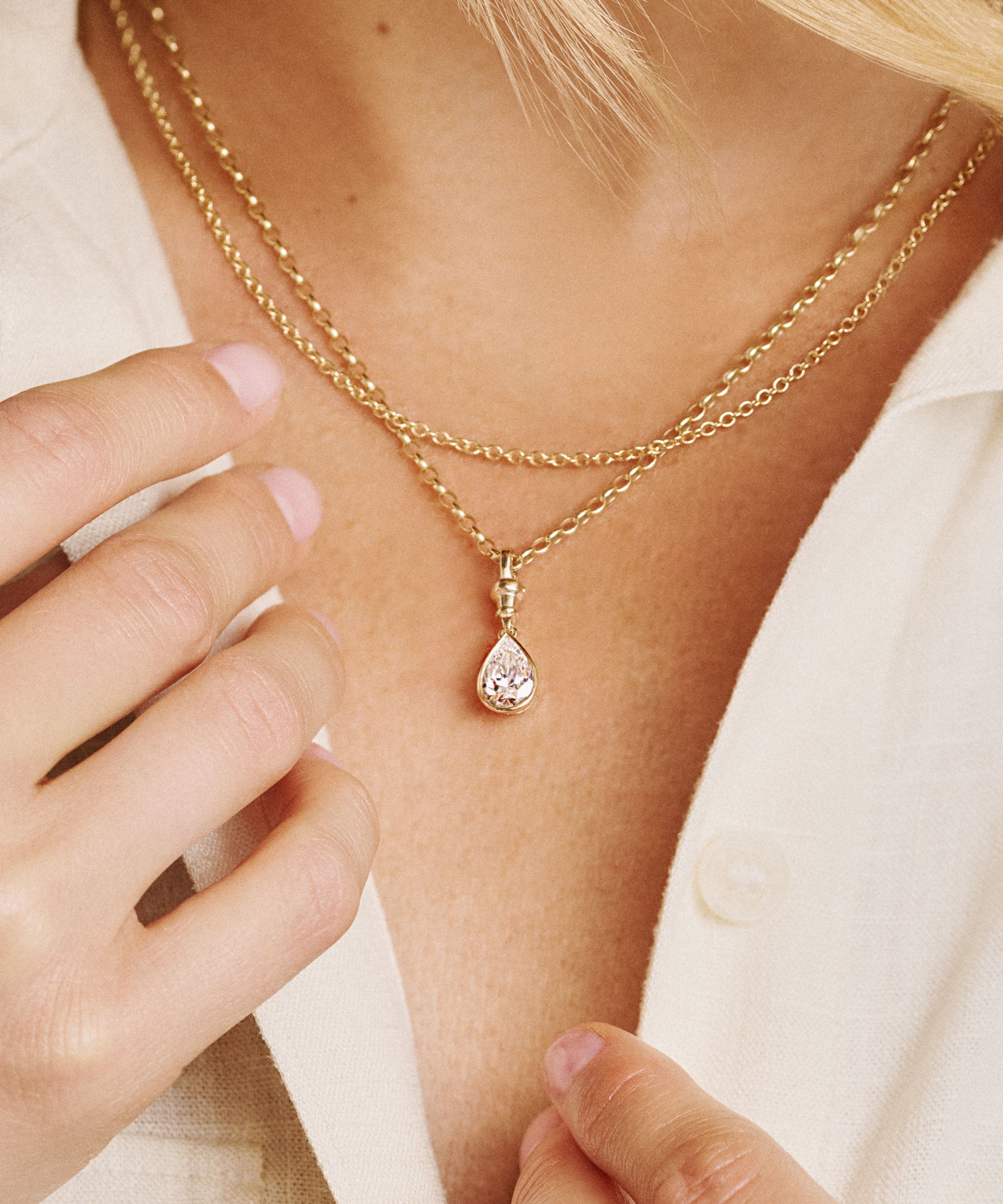 model wearing a 2 carat lab grown diamond pear shaped yellow gold vintage inspired diamond pendant