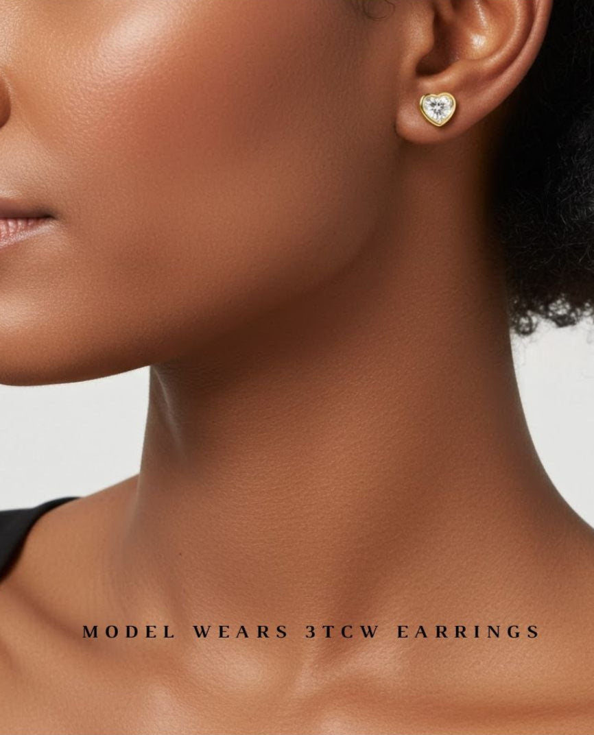 model wearing 3 carat heart shaped bezel set earrings. lab grown diamonds and recycled yellow gold