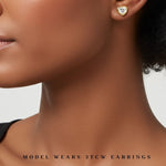 model wearing 3 carat heart shaped bezel set earrings. lab grown diamonds and recycled yellow gold