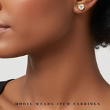 model wearing 3 carat heart shaped bezel set earrings. lab grown diamonds and recycled yellow gold