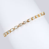 7ct lab grown pear diamond tennis bracelet in 18k gold wrapped around white card 