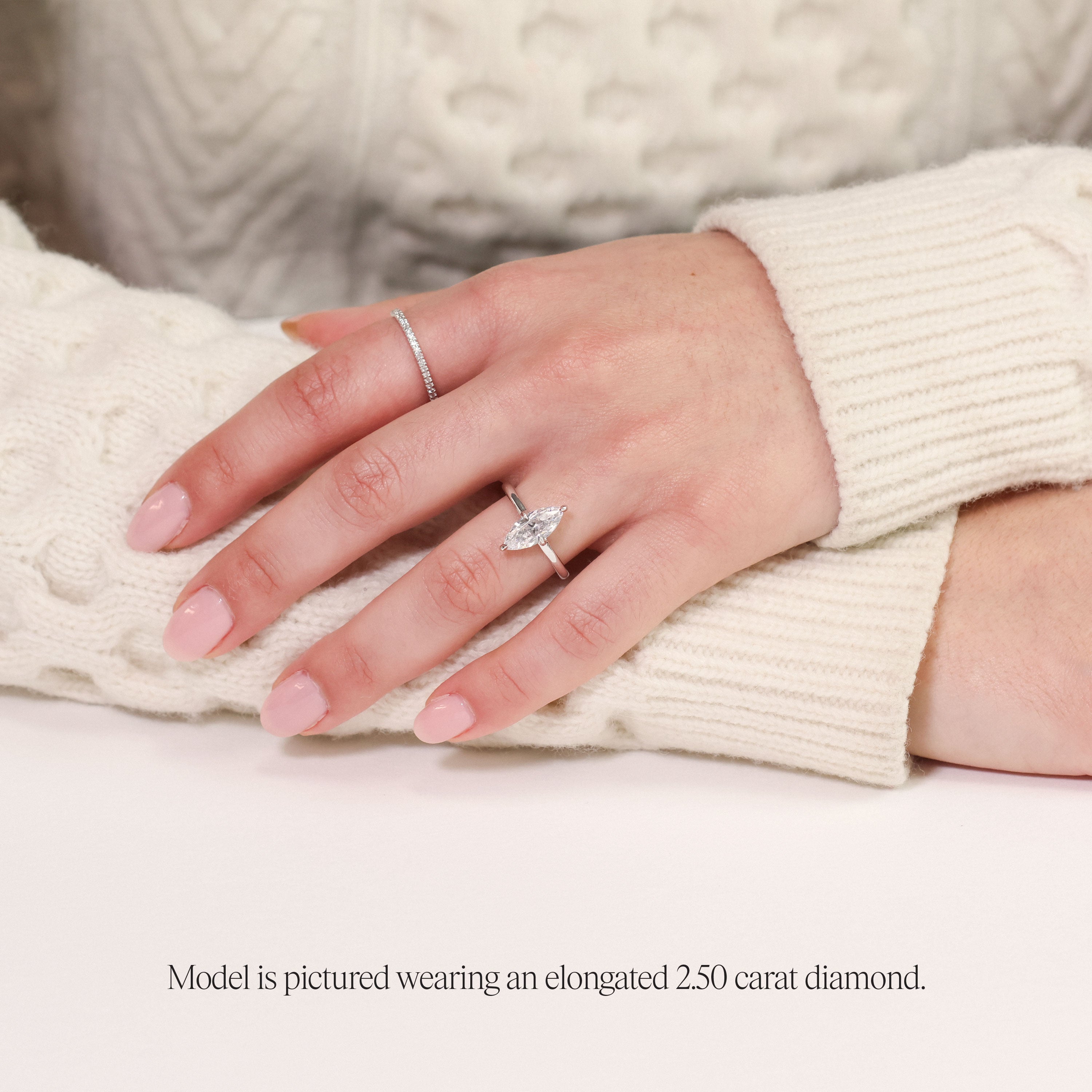 model wearing a 2.5 carat marquise diamond solitaire engagement ring. Featuring a lab grown diamond set in platinum. 