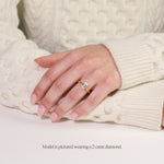 model wearing yellow gold lab grown emerald cut solitaire engagement ring with cathedral setting. 2 carat