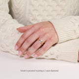 model wearing yellow gold lab grown emerald cut solitaire engagement ring with cathedral setting. 2 carat