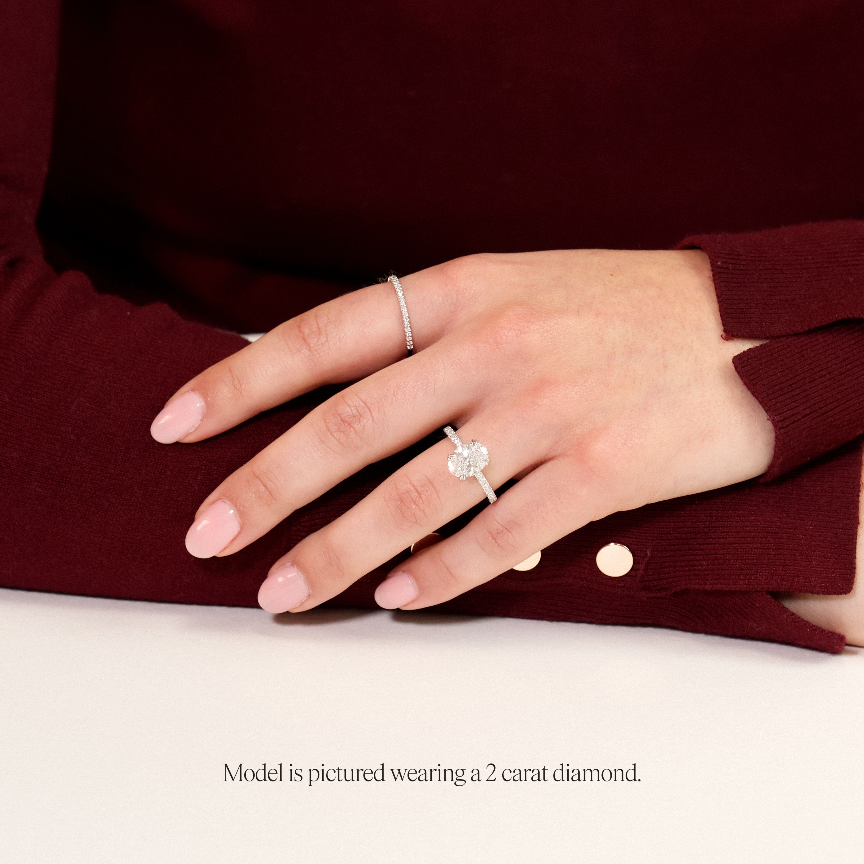 model wearing 2ct oval engagement ring with diamond set band in rose gold