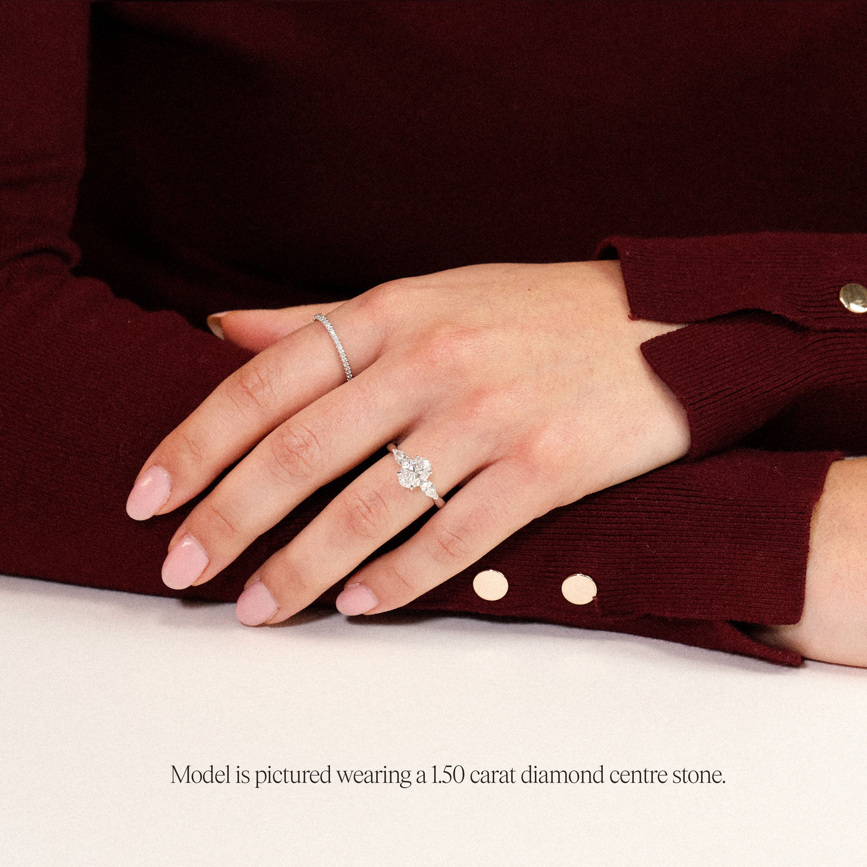 model wearing platinum oval engagement ring. Lab grown trilogy with side pears