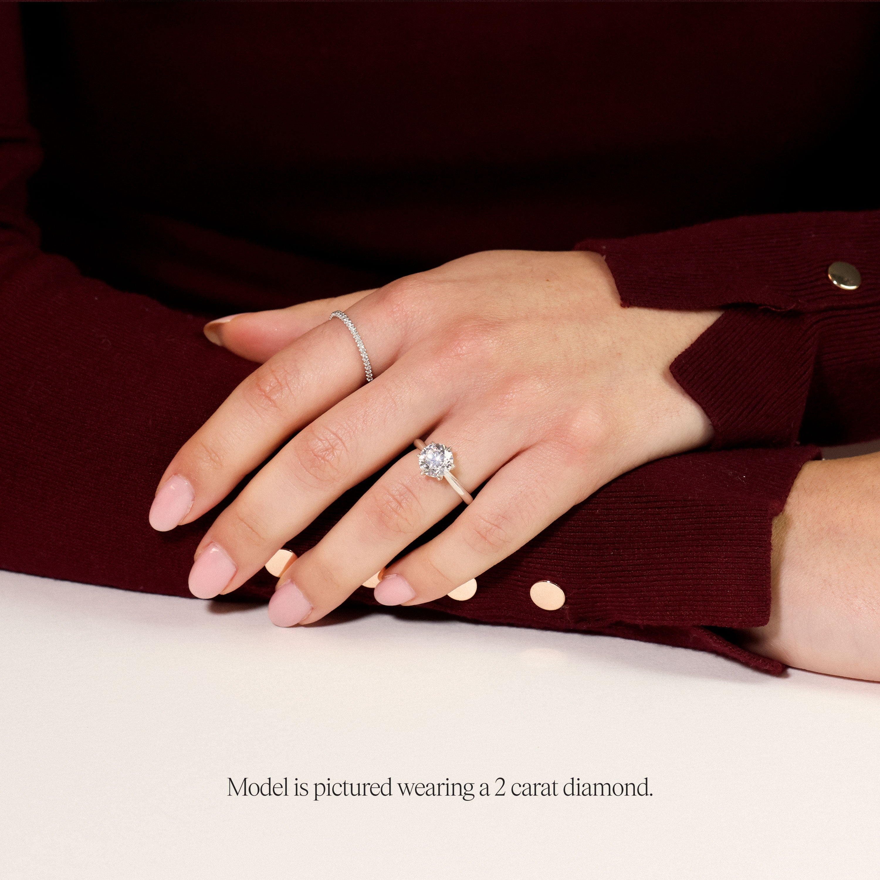 model wearing a round solitaire engagement ring with six claws. featuring a round lab grown diamond in platinum