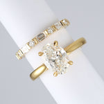 yellow gold round and baguette wedding ring made out of lab grown diamonds and recycled precious metals. Next to an oval engagement ring