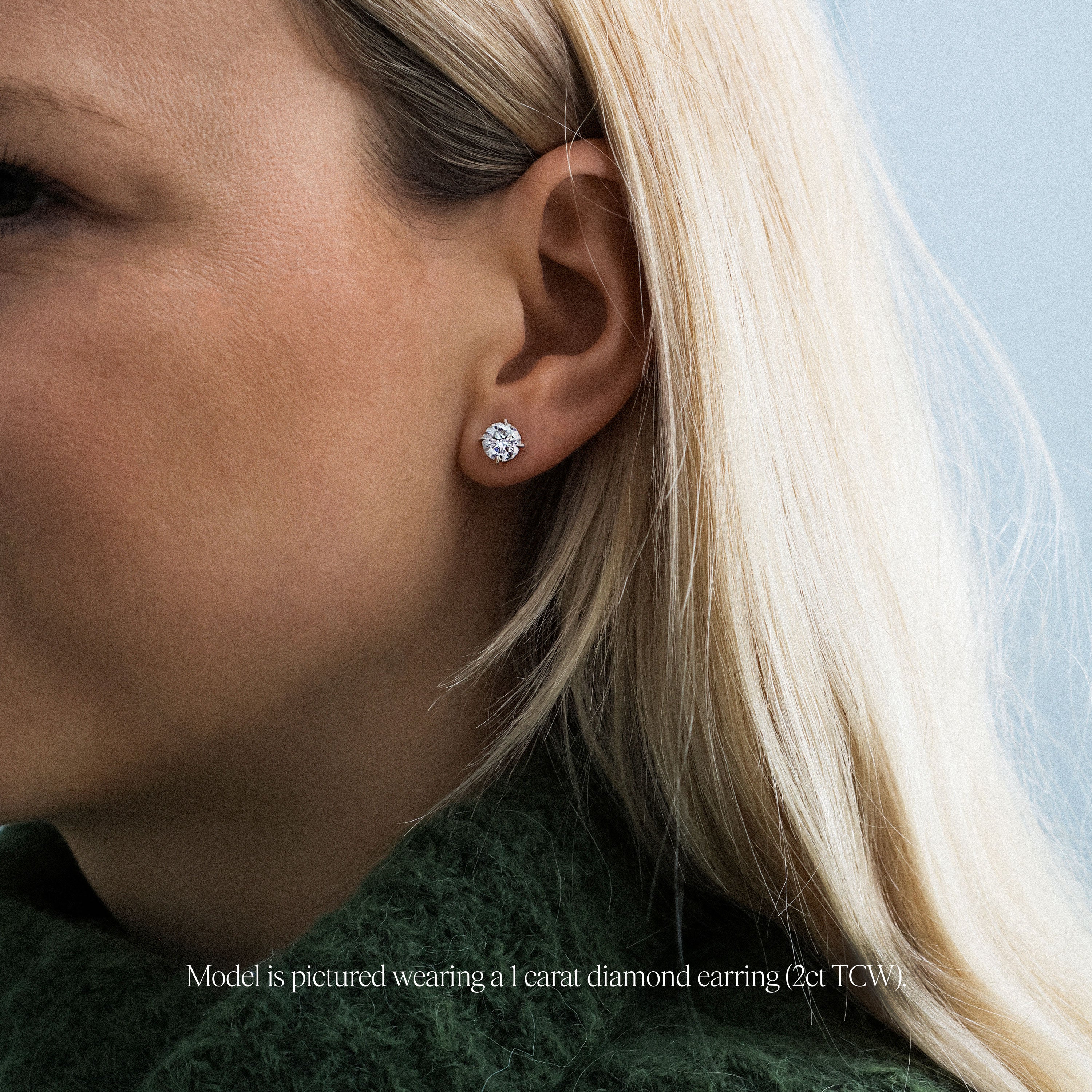 model wearing 1 carat round lab grown diamond stud earrings. Platinum