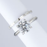 skinny baguette wedding band in platinum. made with lab grown diamonds and recycled precious metals. sat next to round engagement ring